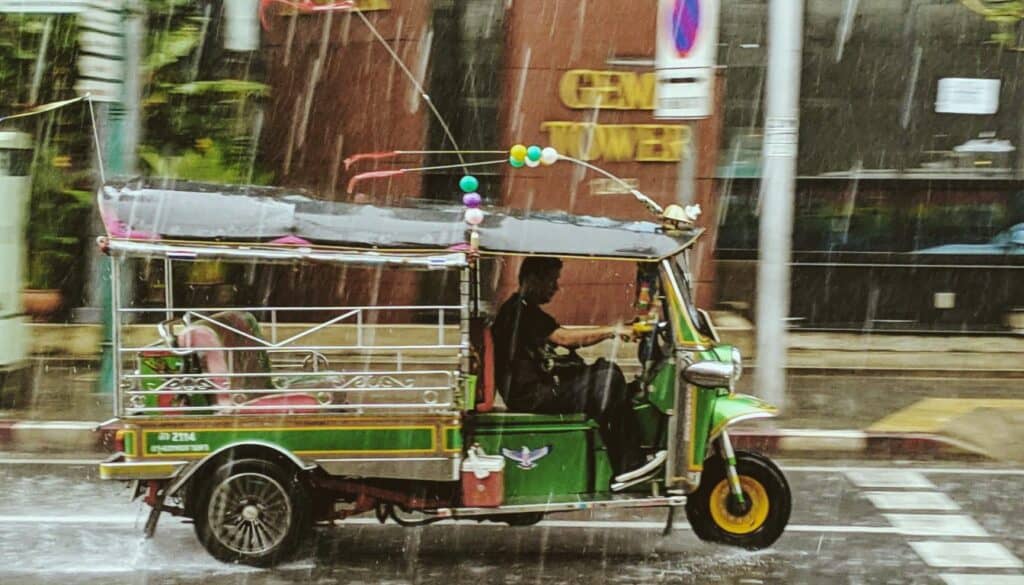 image of a tuktuk in Thailand, driving in the rain. This is clearly taken during the Thai rainy season